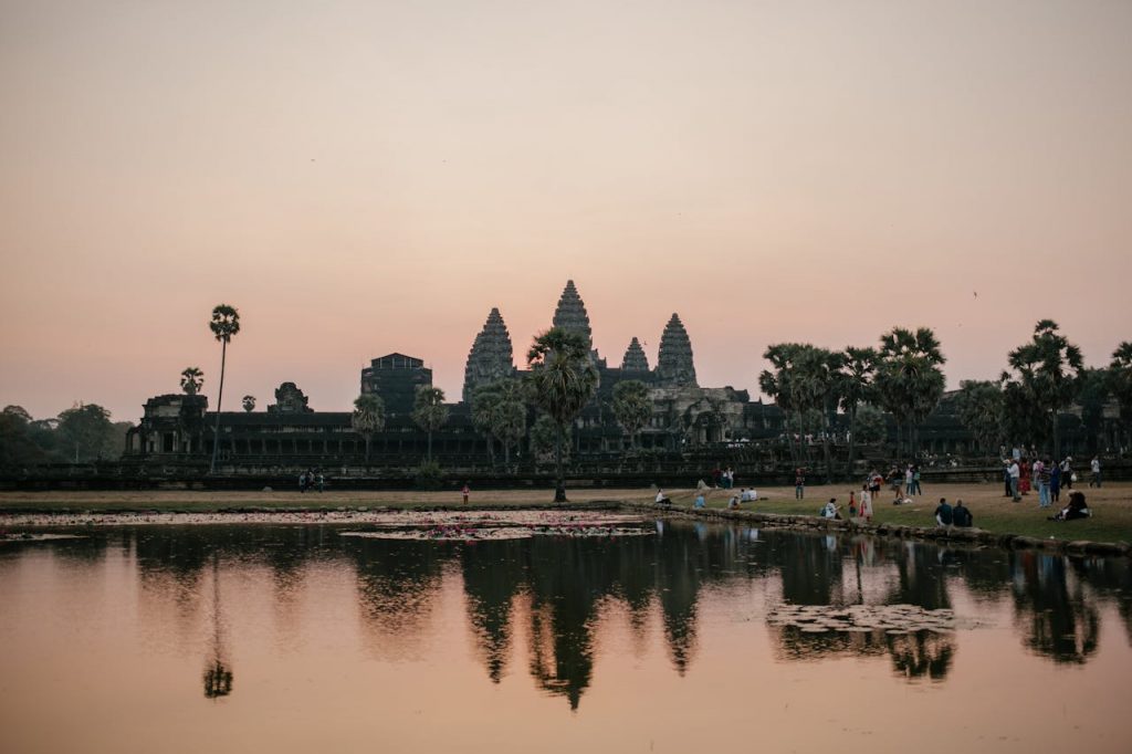 Angkor Wat Tempelanlage in Kambodscha bei Sonnenaufgang mit Wasserreflexion – beliebtes Reiseziel für Touristen